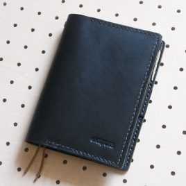 ほぼ日手帳カバー（A6文庫）商品画像000：ほぼ日手帳用のカバーですが、A6サイズのノートも収納可能です。ペンケースが内部に収納されるようになっています。見開き左にポケットがあり、A4の四折りメモや名刺などを収納できます。
